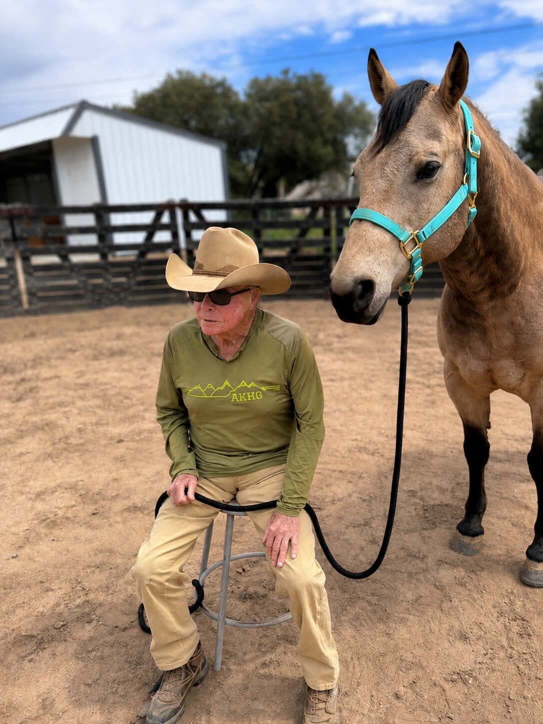 Pete sitting beside a horse at Robin's Nest Rescue.