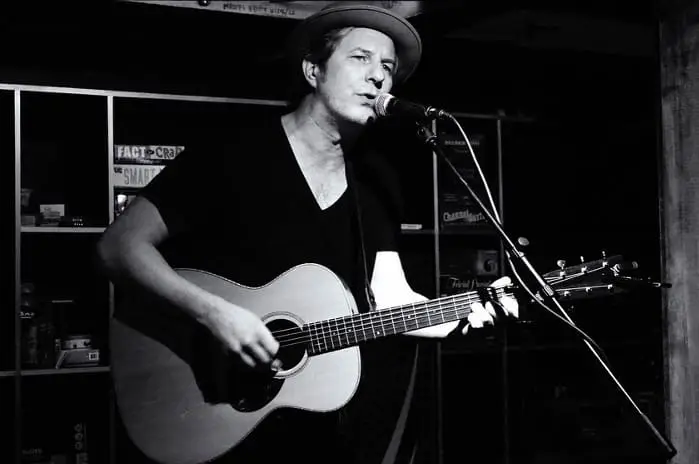 Eddy Green performing with an acoustic guitar.