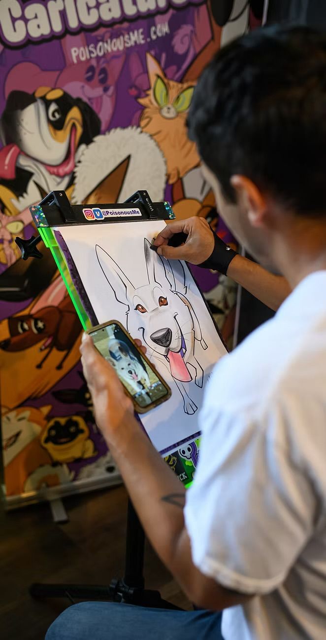 Pet caricature artwork displayed at a vendor booth.